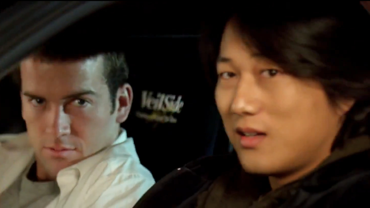 Lucase Black und Sung Kang schauen in „The Fast and the Furious: Tokyo Drift“ aus ihrem Auto.