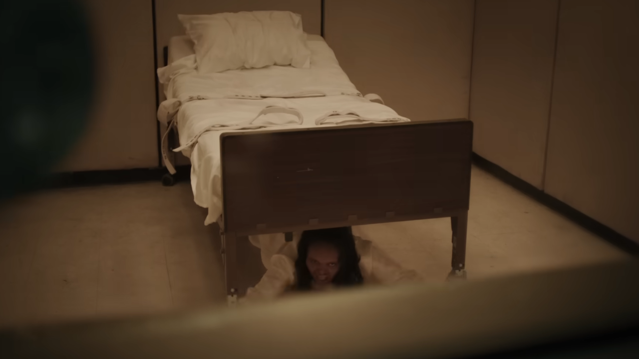 Ein besessenes Mädchen, das sich in „The Exorcist: Believer“ unter dem Bett versteckt.