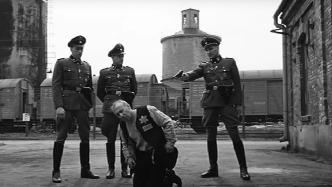 Нацисты стоят над узником-евреем из 