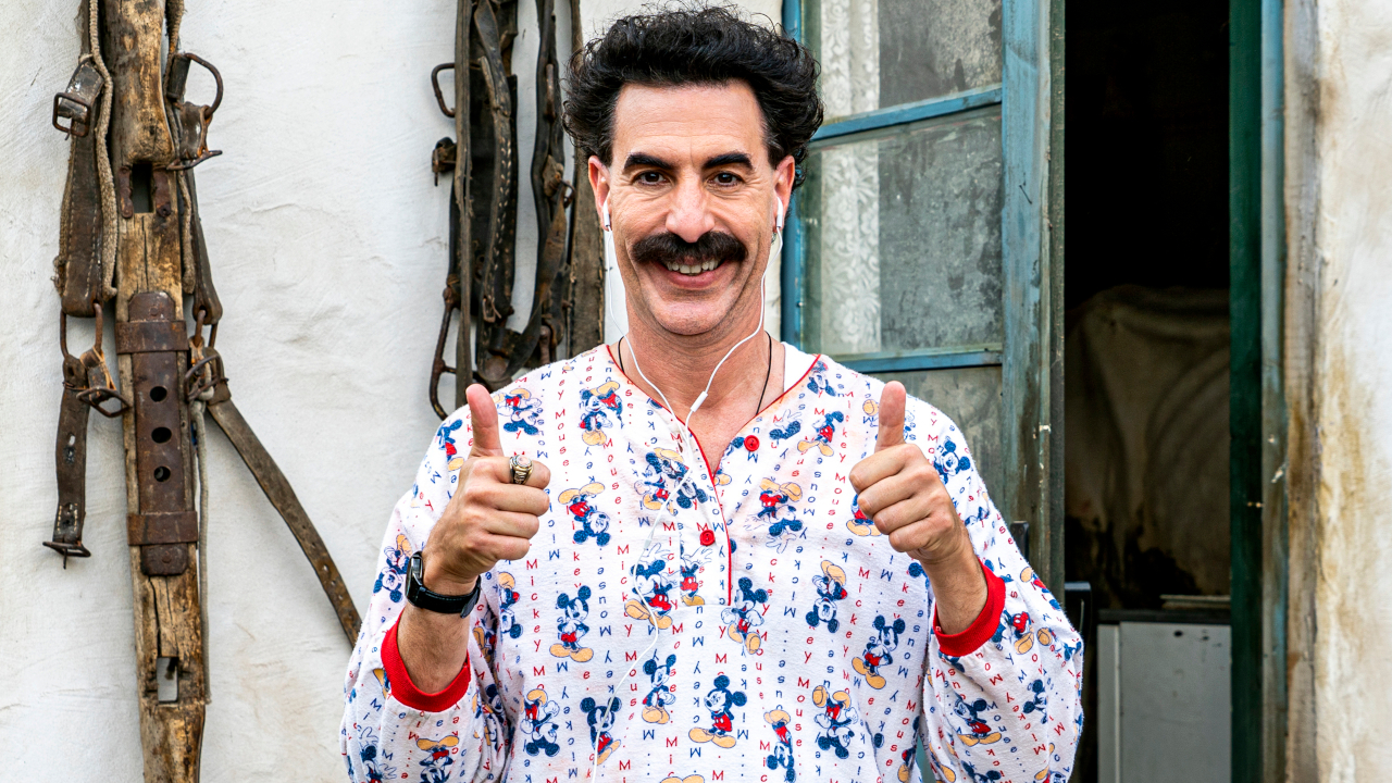 Sacha Baron Cohen zeigt in „Borat Subsequent Moviefilm“ den Daumen hoch, während er einen Mickey-Mouse-Pyjama trägt.