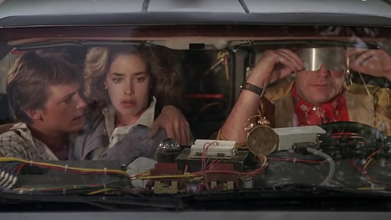 Майкл Джей Фокс, Клаудия Уэллс и Кристофер Ллойд сидят в DeLorean в фильме «Назад в будущее».