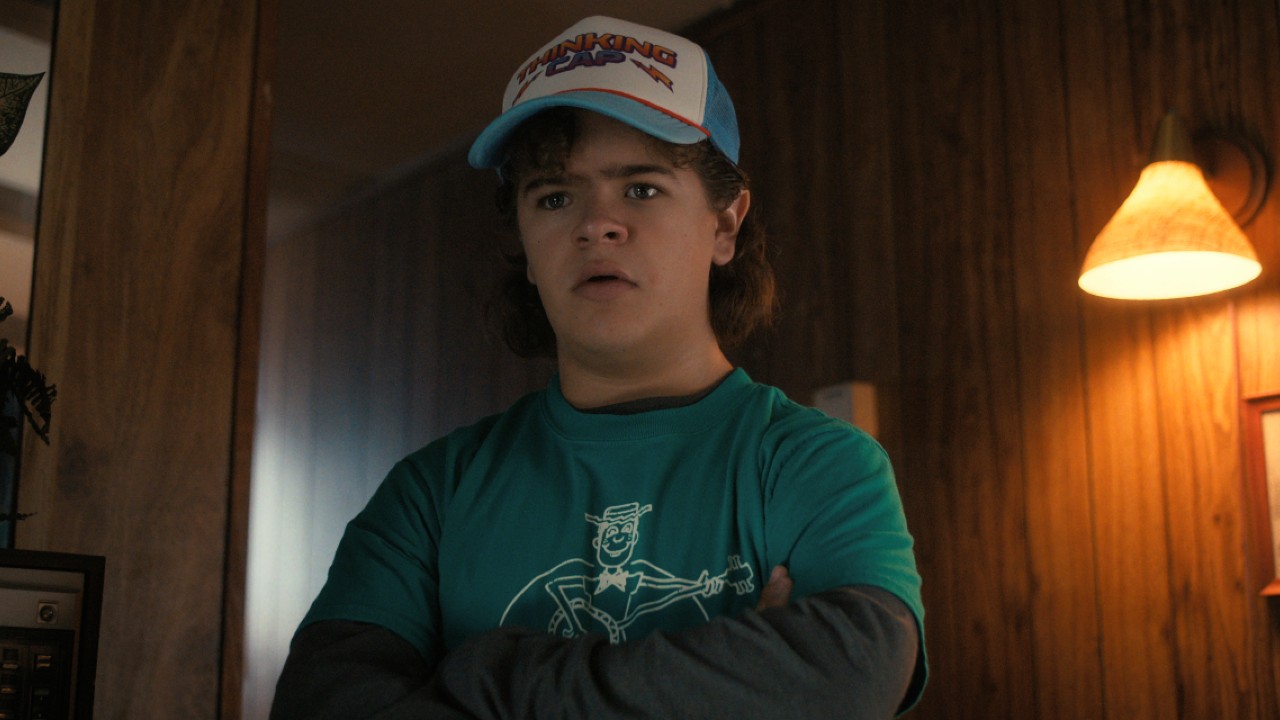Une image de presse de Dustin croisant les bras dans la saison 4 de Stranger Things.