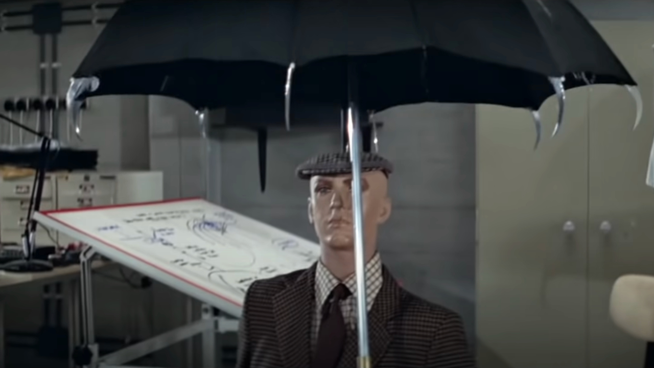 Зонт с шипами, который держат над испытательным манекеном, в фильме «Только для твоих глаз».