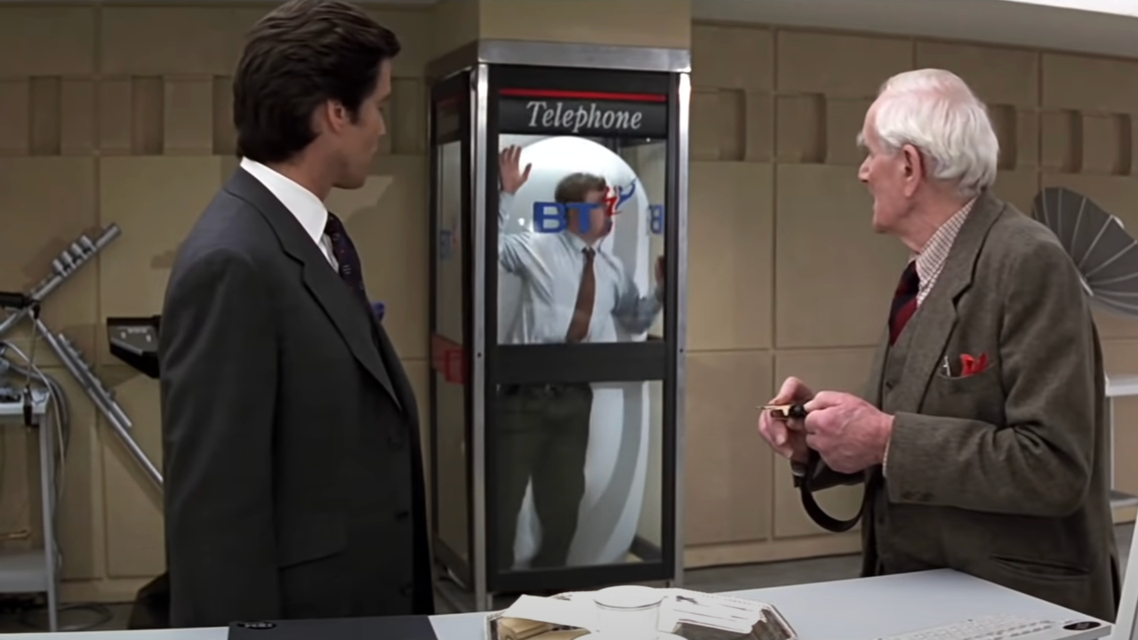 Пирс Броснан и Десмонд Ллевелин смотрят, как взрывается удушающая телефонная будка в «Золотом глазу».