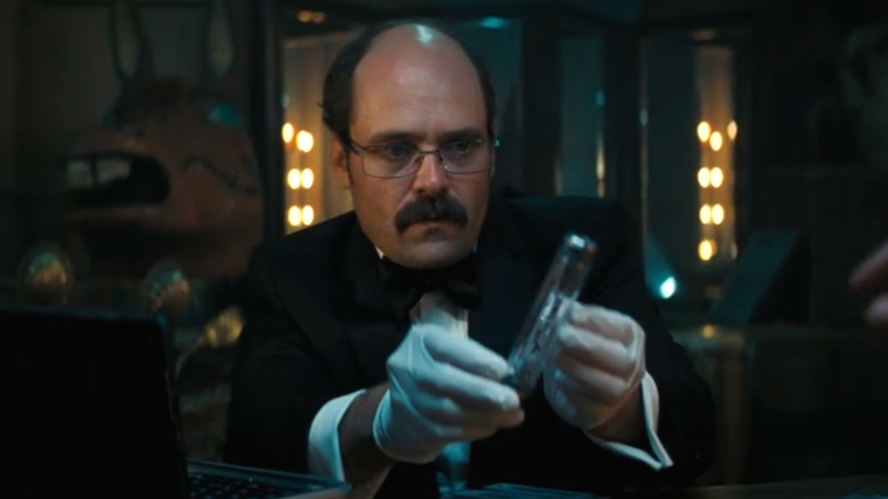 Дэвид Денчик передает флакон с проектом «Геракл» в фильме «Не время умирать».