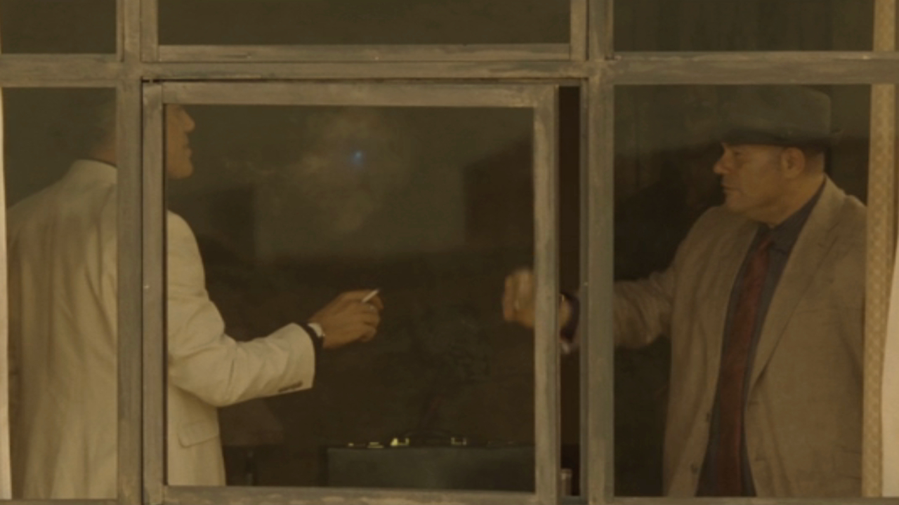 Приспешники поднимают стакан и обнаруживают синий следящий лазер в Spectre.