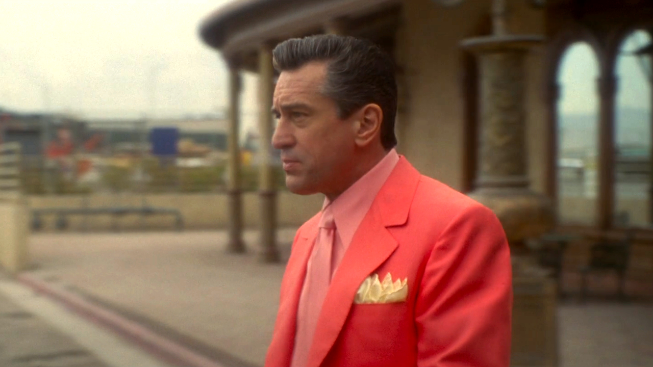 Robert DeNiro geht in einem rosa Anzug im Casino zum Parkplatz.