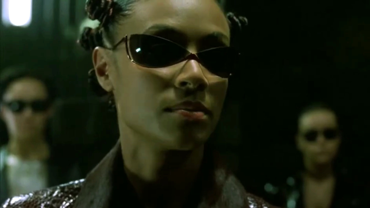 Jada Pinkett Smith gibt in „Matrix Reloaded“ eine Einweisung mit Sonnenbrille.