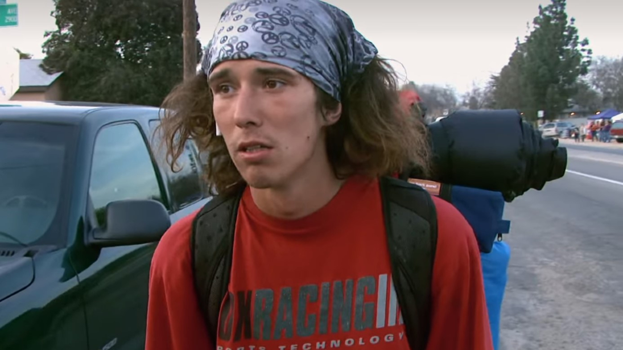 Kai Lawrence speaking with a reporter in The Hatchet Wielding Hitchhiker