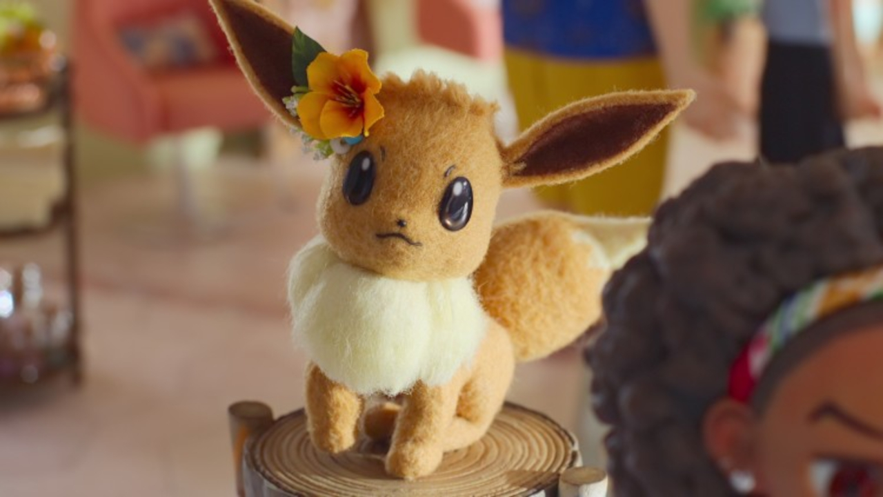 Ein Evoli sitzt bezaubernd mit einer Blume im Haar im Pokémon Concierge.