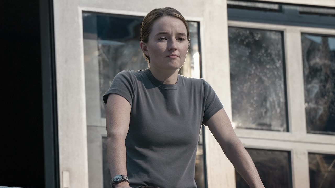 Abby standing outside looking at WLF's stadium camp in The Last of Us Season 2 finale