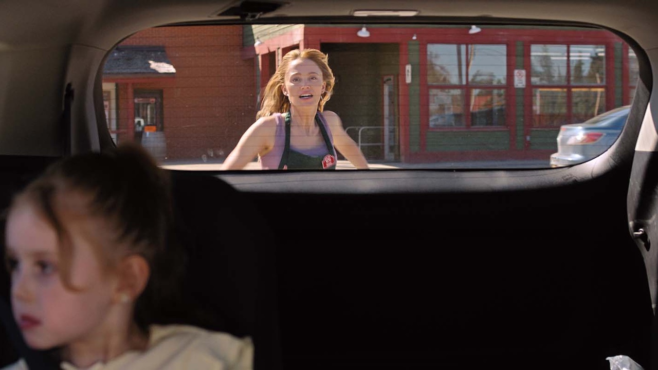 vue depuis la vitre arrière d'une voiture alors que Maika Monroe court après elle dans Reminders Of Him