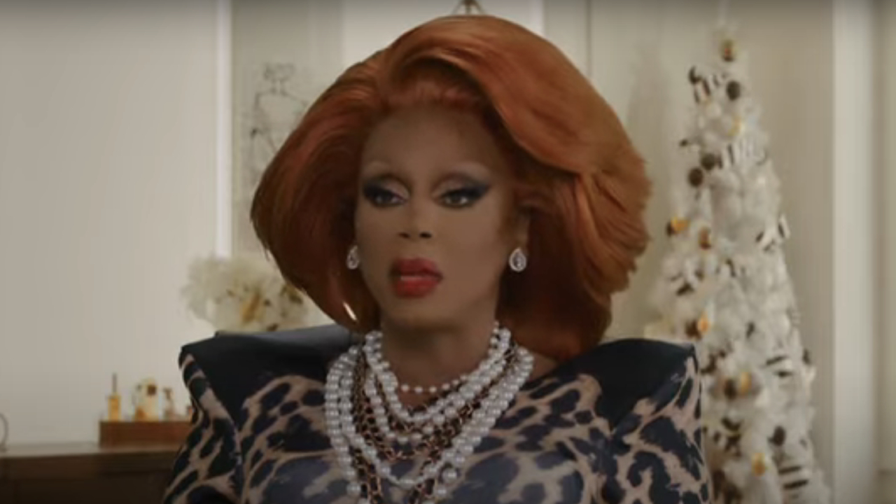 RuPaul with Christmas decorations behind her in The Bitch Who Stole Christmas