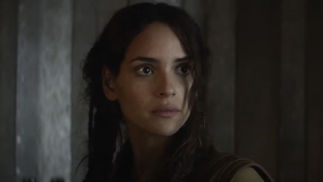 Adria Arjona dans le rôle de Bix Caleena debout devant un mur gris à Andor