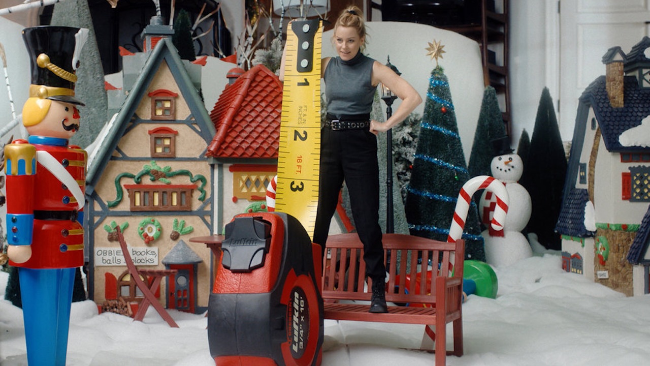 Elizabeth Banks se mesure avec un mètre ruban dans The Miniature Wife
