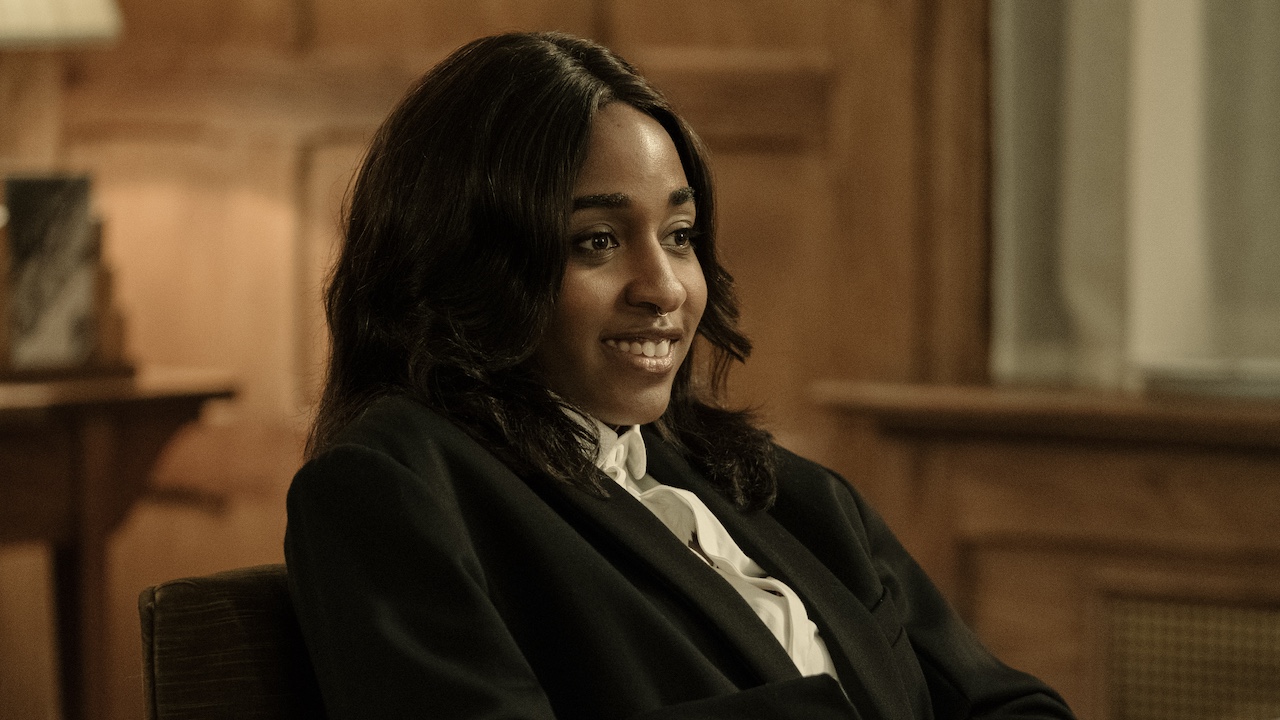 Ayo Edebiri im Anzug sitzt in After The Hunt in einem Büro