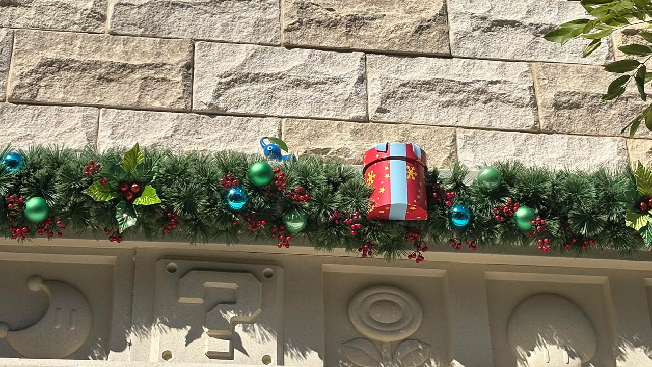 Die Pikmin verstecken sich im Nintendo Super Store im Epic Universe. Auf dem Bild ist das Gebäude weihnachtlich geschmückt.