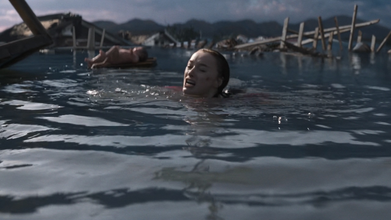 Лиза плавает в воде в ожидании приближающейся акулы, а ребенок плавает на заднем плане в фильме Netflix «Трэш»