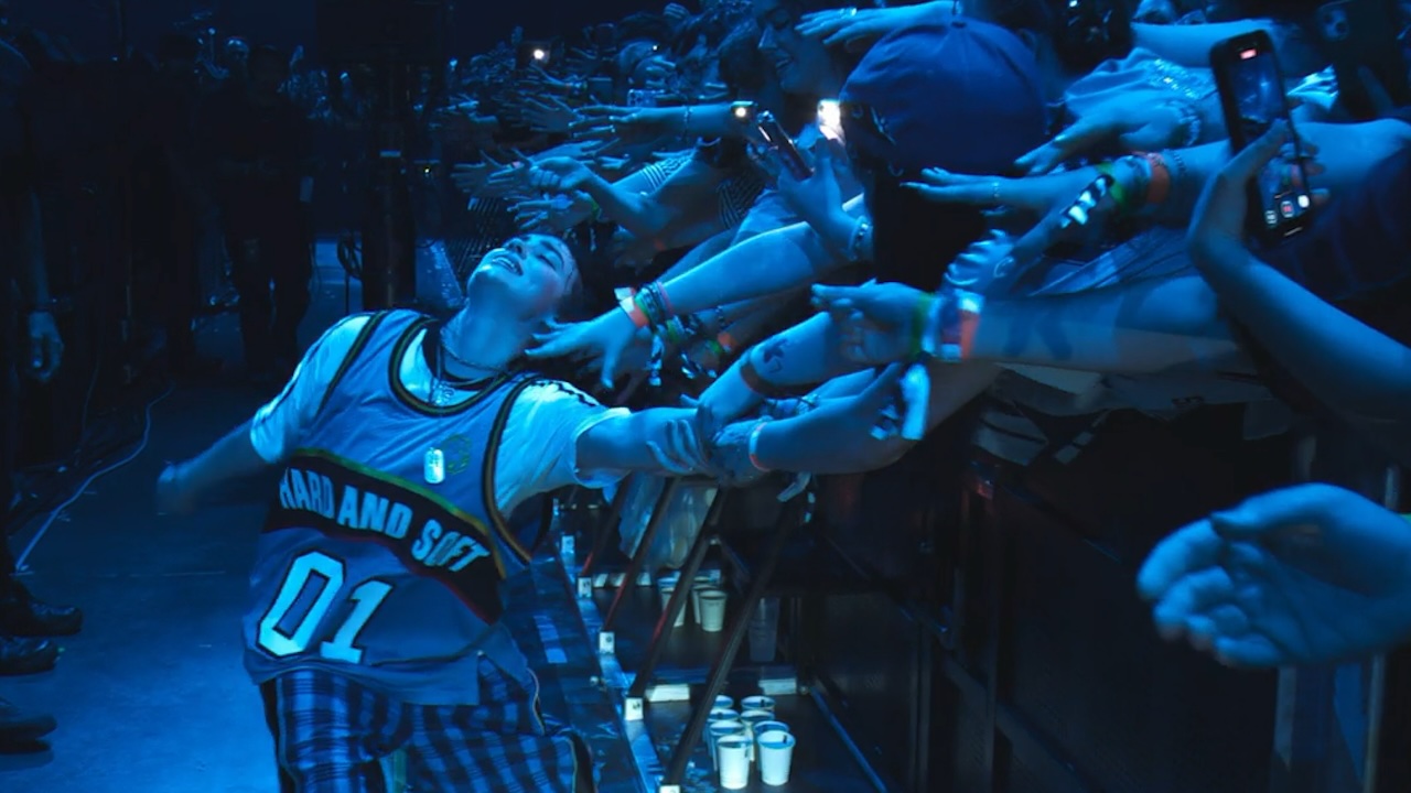 Billie Eilish lehnt sich zurück und lässt sich von den Fans in Billie Eilish Hit Me Hard And Soft The Tour (Live in 3D) berühren.